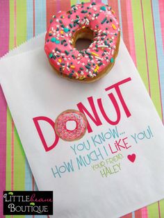 a donut with sprinkles on it sitting on top of a paper bag