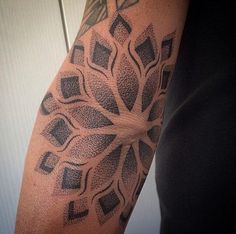 a man with a tattoo on his arm has a black and grey design on it