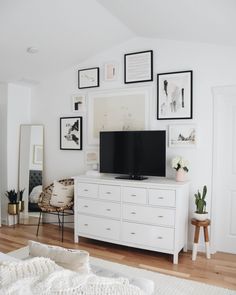 a flat screen tv sitting on top of a white dresser