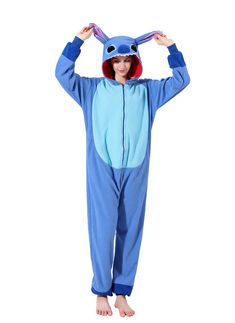 a person in a blue animal onesuit standing with their hands on his head and one hand up