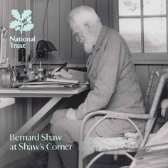 a man sitting at a desk writing in front of a computer monitor with the words bernard shaw at shaw's corner