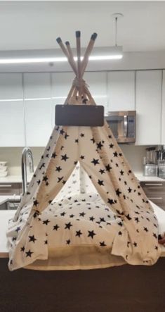 a teepee with black stars on it is in the middle of a kitchen area