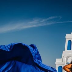 a woman is standing in front of a blue and white church