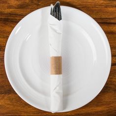 a white plate topped with a purple napkin and two black forks sitting on top of it