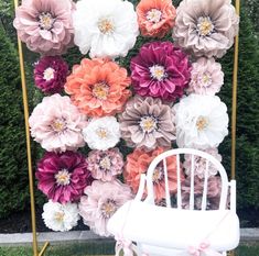 a white chair sitting in front of a flower wall