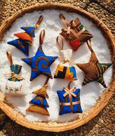 a basket filled with different colored ornaments on top of a white tablecloth covered floor