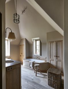 a bathroom with a large tub and wooden floors