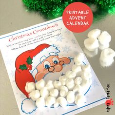 a printable christmas calendar with marshmallows and santa hat on it, next to some candy