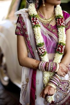 a woman in a bridal outfit standing next to a car