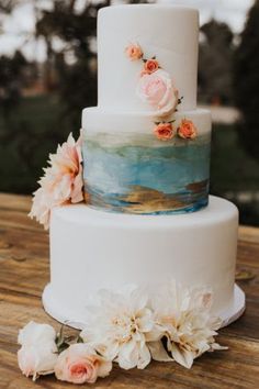 a three tiered cake with flowers on top