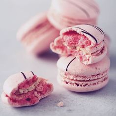 several pink macaroons with one broken in half