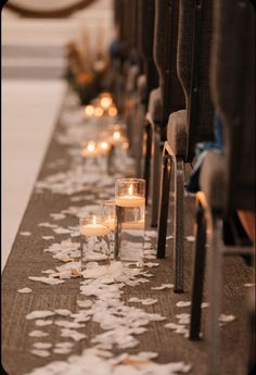 rows of pews with candles and petals on the floor