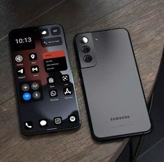 two smartphones sitting on top of a wooden table next to an iphone 11 pro