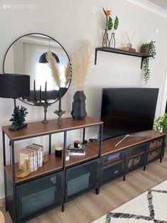 a living room filled with furniture and a flat screen tv on top of a wooden shelf