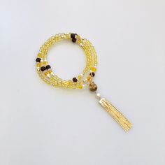 ⚜ Return to Origin Yellow Crystal Beaded Necklace ❀ Yellow Crystal 4mm❀ Gold Plated Sterling Silver Clasp and Spacer 2-4mm❀ Fresh Water Pearl 4mm❀ White and Yellow Jade 3-6mm; ❀ Rosewood Lotus 8-10mm❀ Beaded Chain 24 in. with Black Glasses Chain Connectors❀ Multiple Styles ⚜ Auspicious Clouds Tassels ❀ Rosewood Auspicious Clouds❀ Natural Yellow Jade❀ Gold Plated Metal Tassel with Manmade Pearls❀ Length 3 in. with Sterling Silver Ear Wire to Style as Earrings ⚜ Jade Lotus Tassel Pendant ❀ Natural Bohemian Gold Beaded Bracelets For Meditation, Gold Beaded Bracelets With Dangling Beads, Adjustable Yellow Lariat Jewelry, Adjustable Yellow Lariat Necklace, Bohemian Gold Tassel Necklace For Gift, Bohemian Gold Tassel Necklace As Gift, Elegant Yellow Beaded Bracelets With Gold Beads, Elegant Yellow Beaded Bracelet With Gold Beads, Bohemian Gold Tassel Necklace