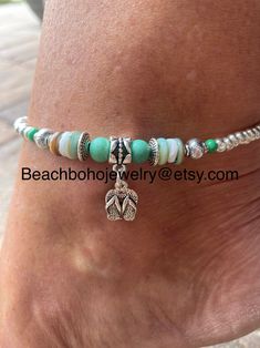 This beautiful beach ankle bracelet for women is made with green stone beads, white and green shell beads, silver Tibetan beads, a silver flip flop charm, and silver glass beads. Don't like the flip flop charm? I have several to choose from. Just message me your preference and I'll see what I can do for you! Ankle bracelet comes in several sizes, just choose your size from the drop down menu at checkout. Don't see your size? Just message me and I'll be happy to make your size for you! Silver Bohemian Strand Anklets, Beach Season Vacation Anklet With Tiny Beads, Adjustable Silver Anklets For Vacation, Silver Adjustable Anklets For Vacation, Bohemian Anklets With Round Beads For Beach Season, Silver Strand Anklets For Beach Season, Handmade Silver Strand Anklets, Summer Beach Anklets With Silver Beads, Beaded Anklets For Beach Season Gift