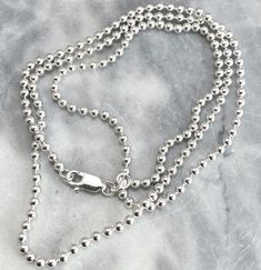 "Solid 925 Sterling Silver Chain Design: Ball Chain Also available in Box, and Cable& Figaro Design. Versatile, high-quality chain made of genuine sterling silver with 925 stamp and spring ring lock. It is hypoallergenic (nickel and toxic-chemical free) thus not prone to any allergies. Available in:  16 inches 18 inches 20inches If you want in any other size& design, i can make it for you. USE: It makes the perfect gift, too. - Add your own pendants. - Great for wearing on their own. - Wear them layered with other necklace Ball chain measures 1.25mm beads, and all chains includes most commonly length i.e. 16\", 18\" and 20\". For specific design or measurement, feel free to reach out, AFTER CARE: It is given in a Ziploc bags. These are the best and very affordable way to keep your sterling White Gold Ball Chain Necklace Gift, Classic Ball Chain Necklace As Gift, Classic Sterling Silver Necklace With Ball Chain, Silver Ball Chain Necklace As A Gift, Silver Necklace With Ball Chain As Gift, Silver Necklace With Ball Chain For Gift, White Gold Ball Chain Necklace As Gift, Silver Jewelry With Box Chain And Round Beads, Silver Necklace With Box Chain And Round Beads