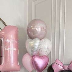 pink and white balloons are on display in front of a mirror