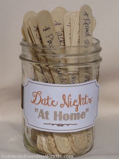 a jar filled with lots of gold colored straws next to a white label that says date nights at home