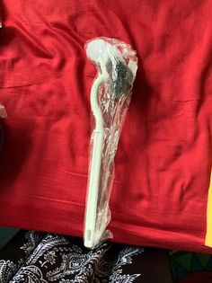 a toothbrush is wrapped in plastic on a red cloth