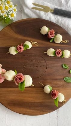 a wooden platter with flowers and leaves on it