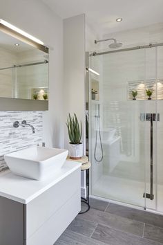 a bathroom with a sink, mirror and shower in it's center area is shown