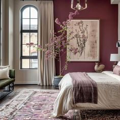 a bedroom with purple walls and white bedding in front of a painting on the wall