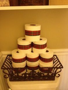 a stack of toilet paper sitting on top of a metal rack next to a wall