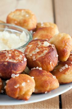 a white plate topped with pastries next to a bowl of dip