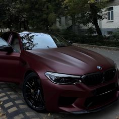 a maroon car parked on the side of a road