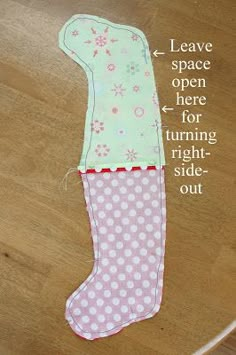 an oven mitt made out of pink and white polka dots on a wooden floor