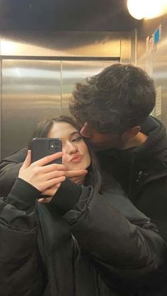 a man and woman taking a selfie in an elevator