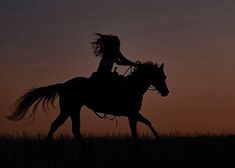 a girl riding on the back of a horse at sunset or dawn with her hair blowing in the wind