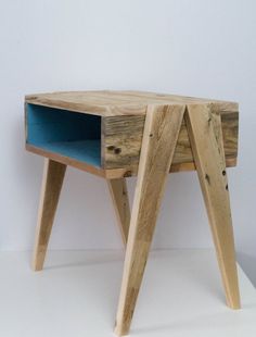 a small wooden table with a blue drawer on the top and legs that have been made out of wood