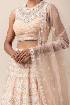 Peach lehenga with aari threadwork and highlighted with pearls-sequin. Comes with fluted blouse enhanced with French knots-pearl work and embroidered dupatta. 
Component: 3
Embroidered
Neckline: Round
Sleeve Length: Sleeveless
Fabric: Sheer Silk, Net, Chiffon
Color: Peach
Sheer panel
Cutout back - Aza Fashions Fitted Net Choli With Cutdana, Chandbali Wedding Pre-draped Saree, Wedding Choli With Cutdana On Net, Wedding Chandbali Pre-draped Saree, Wedding Choli With Cutdana On Net Material, Lehenga With Cutdana On Net In Traditional Drape, Lehenga With Cutdana In Net With Traditional Drape, Traditional Drape Lehenga With Cutdana On Net, Elegant Wedding Choli In Net