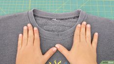 someone is making a t - shirt with their hands on top of the teeshirt