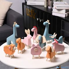 a group of wooden toy animals sitting on top of a white table next to a couch