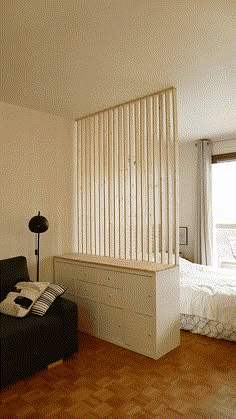 a living room filled with furniture next to a bed and a wooden slatted wall