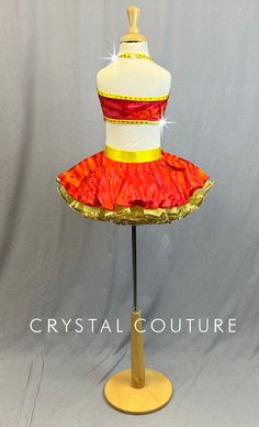 Red and Orange marbled lycra halter dress with open sides and back. Yellow sparkle lycra trim finishes out the seams of this costume as well as a nice thick waistband. This is a full skirt with 4 layers of Yellow glitter tulle ruffle with Gold sequin trim. This costume is finished off with 20ss Fire Opal rhinestones! *Accessories include a feather comb hairpiece. **Costume in image is a YM, Photographed on a YM/YL Mannequin with Measurements of: Bust 27", Waist 24", Hip 27", Girth 47"