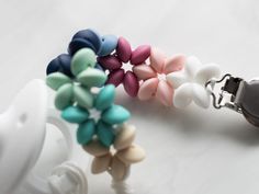 two pacifiers with different colored beads attached to each other on a white surface