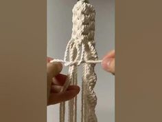 someone is holding the end of a piece of white rope with two ends and one end