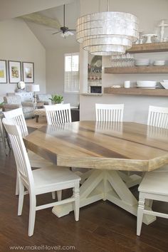 a large wooden table with white chairs around it