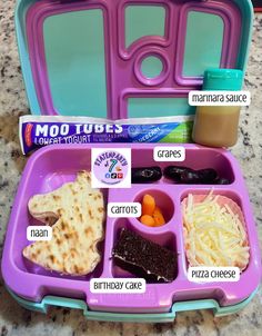 a purple lunch box with compartments filled with food and condiments on the side