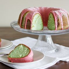 a bundt cake with pink and green icing sitting on a plate next to another bundt cake