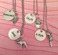 four different necklaces with charms that say assorted, eat or fetch on them