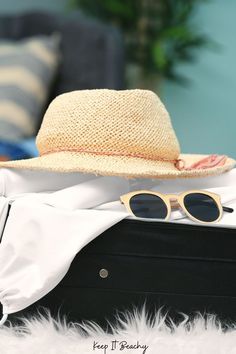 a hat and sunglasses are sitting on top of a suitcase