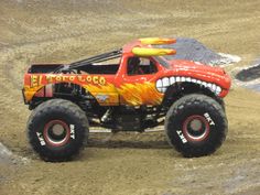 a red monster truck with flames painted on it