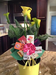 a potted plant sitting on top of a kitchen counter filled with cards and flowers