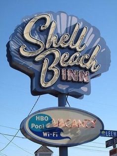 a sign that says shell beach inn on it's side