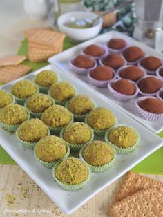 several trays of cupcakes and crackers on a table with other snacks